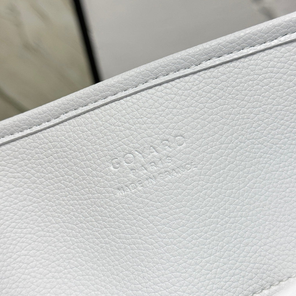 Close-up of a white leather product with 'GOYARD' branding.